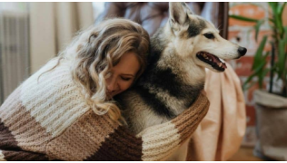 Une femme serre son chien dans ses bras après avoir fait une erreur