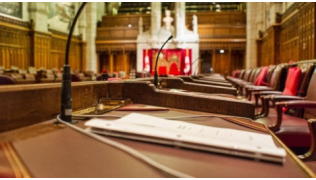Intérieur de sénat avec des rangées de bureaux et des fauteuils rouges