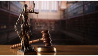 Un marteau de juge et une statue de la dame de la justice représentant la loi dans un tribunal