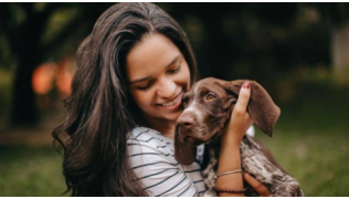 Une maîtresse tient dans ses bras son chiot Pointer